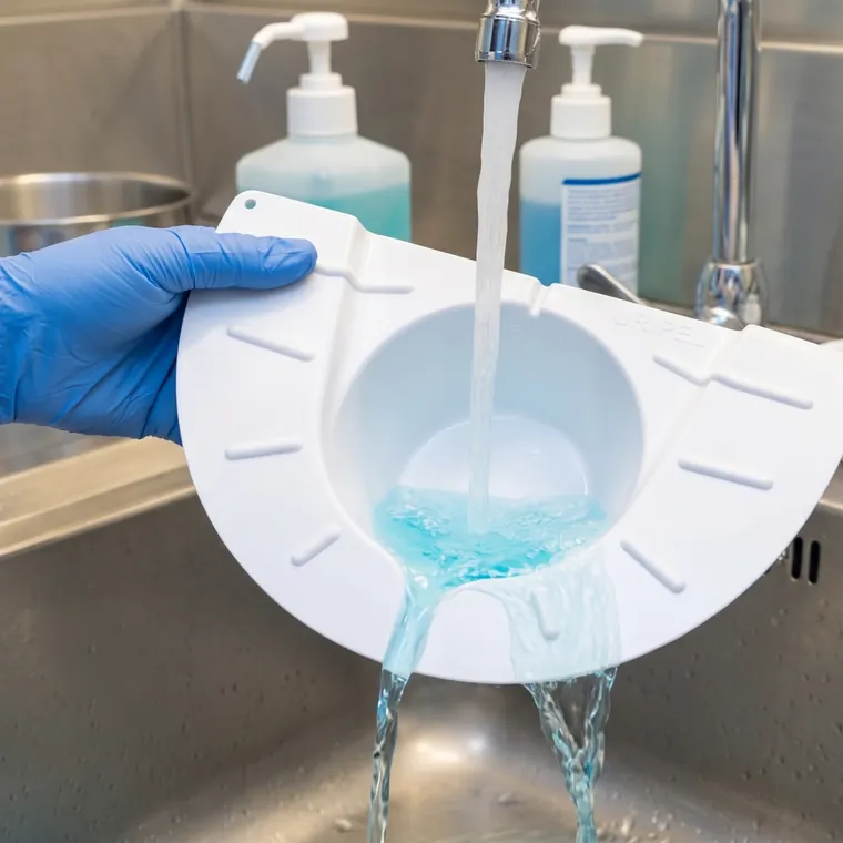Lavado del recolector URIPEL bajo el chorro de agua de una pileta.