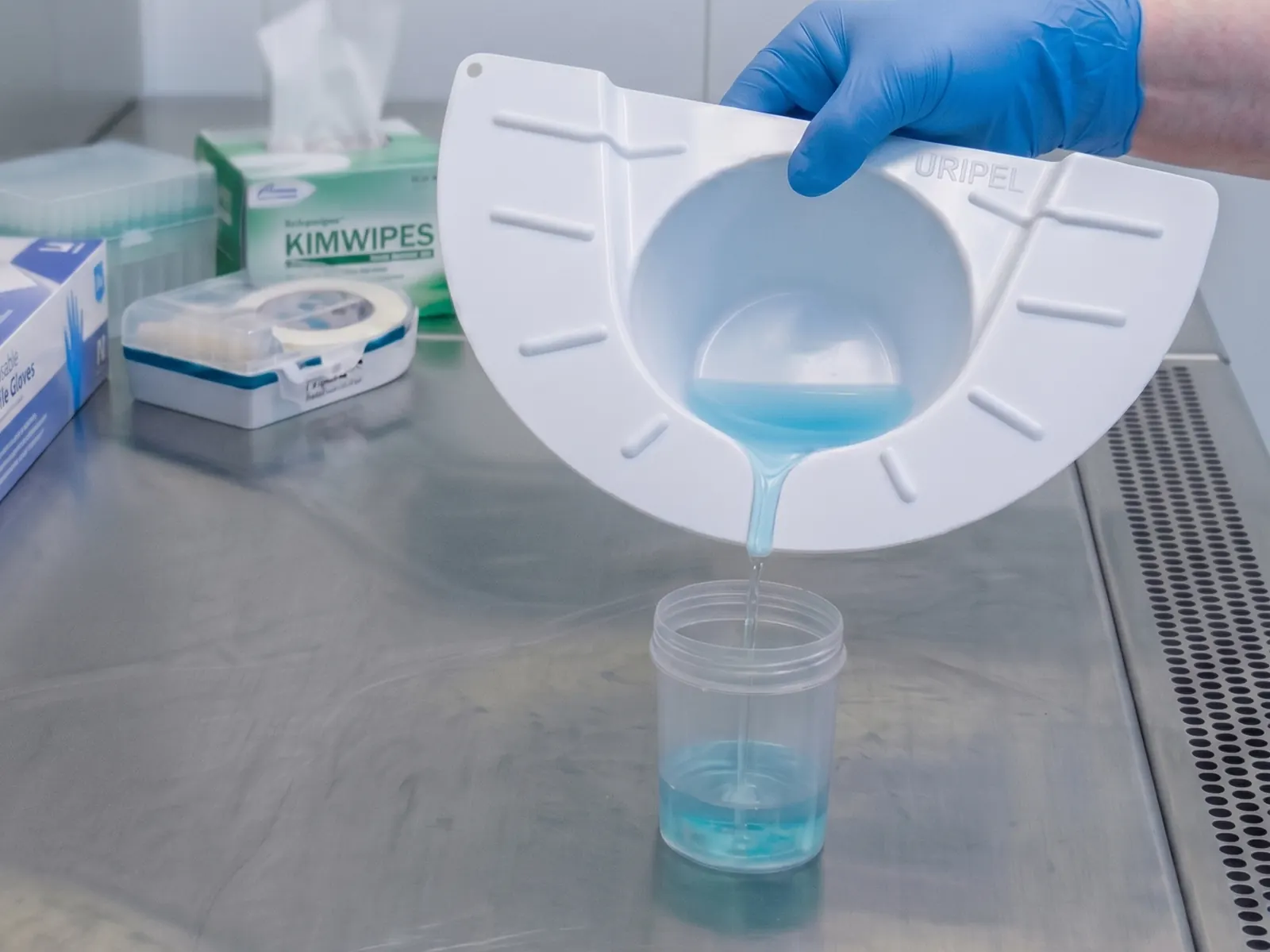 Vuelco de la muestra desde la ranura vertedora de URIPEL hacia un frasco de laboratorio.